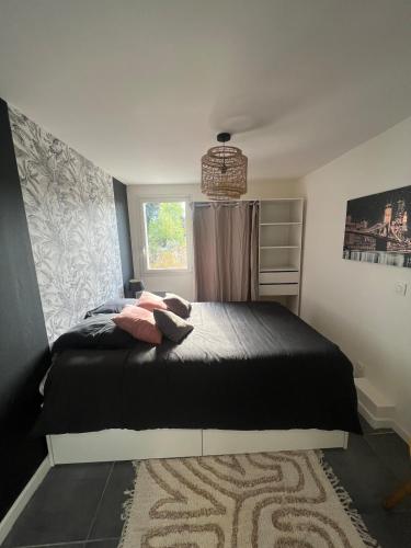 - une chambre avec un lit noir et une fenêtre dans l'établissement Magnifique T2, à La Penne-sur-Huveaune