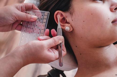 a woman is getting her face combidated with a plastic tool at Hostel Canto da Alegria in Itanhaém