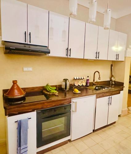 a kitchen with white cabinets and a sink at Edwiria Marrakech in Marrakech