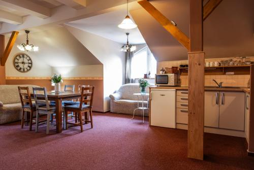 a kitchen and living room with a table and chairs at Penzion Pohoda Sokolov in Sokolov