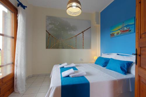 a blue bedroom with a bed with towels on it at BS Village in Metamorfosi
