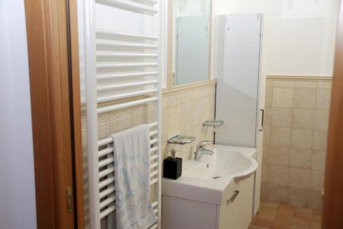 a white bathroom with a sink and a mirror at La Casa della Nonna in Brisighella