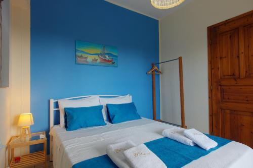 a blue bedroom with a bed with towels on it at BS Village in Metamorfosi
