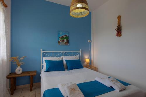 a blue bedroom with a bed with blue walls at BS Village in Metamorfosi
