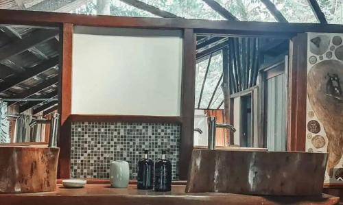 a bathroom with two sinks and a window at Hotel 3 Bamboo Ecolodge in Cahuita