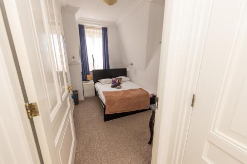 a small bedroom with a bed and a window at Irene's Palace - The Hague Scheveningen in The Hague