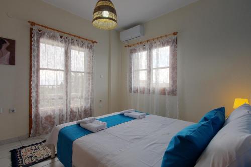 a bedroom with a large bed and two windows at BS Village in Metamorfosi