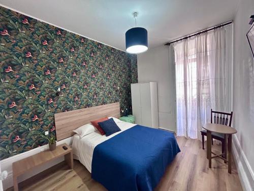 a bedroom with a bed and a wall with flowers at Monte Sinai Guest House in Porto