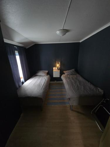 two beds in a small room with blue walls at Lyngenfjord view in Engnes