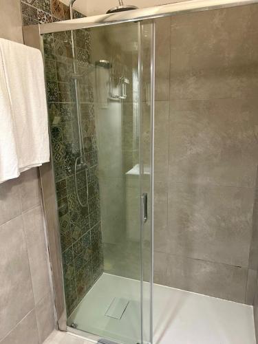 a shower with a glass door in a bathroom at Monte Sinai Guest House in Porto