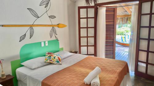 a bedroom with a bed with a branch on the wall at Mangará Hostel e Hospedaria in Ilhabela