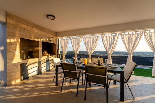 a kitchen and dining room with a table and chairs at MY DALMATIA - Sea view Villa Rica in Podvršje