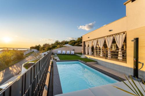 a balcony with a swimming pool and a building at MY DALMATIA - Sea view Villa Rica in Podvršje
