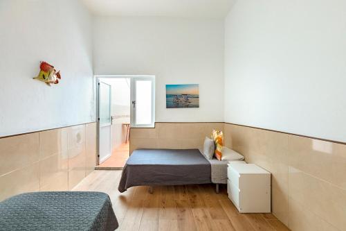 a bedroom with a bed and a mirror in it at SALINETAS BLUE SURF HOUSE in Telde
