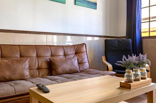 a leather couch in a waiting room with a table at SALINETAS BLUE SURF HOUSE in Telde