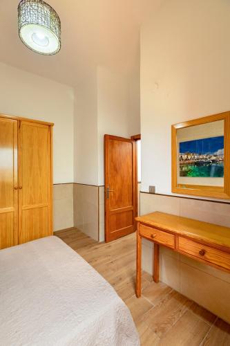 a bedroom with a bed and a wooden table at SALINETAS BLUE SURF HOUSE in Telde
