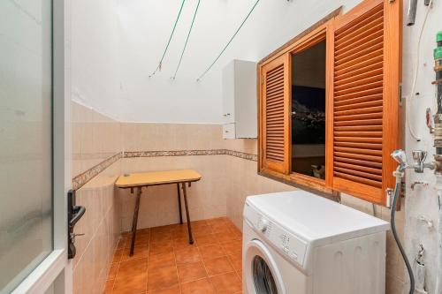 a laundry room with a washing machine and a table at SALINETAS BLUE SURF HOUSE in Telde