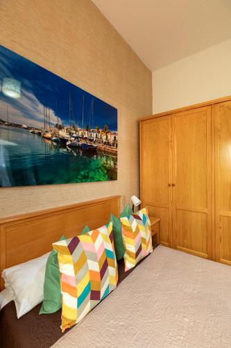 a bedroom with a bed with a painting on the wall at SALINETAS BLUE SURF HOUSE in Telde