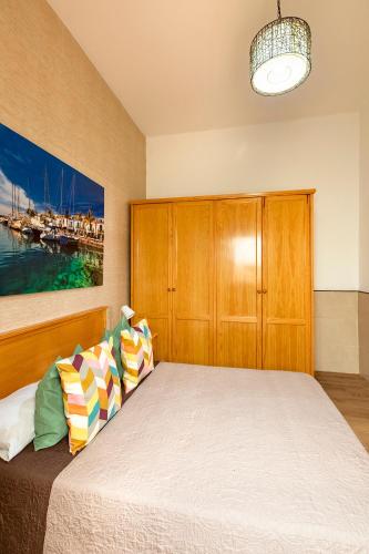a bedroom with a bed with a wooden cabinet at SALINETAS BLUE SURF HOUSE in Telde