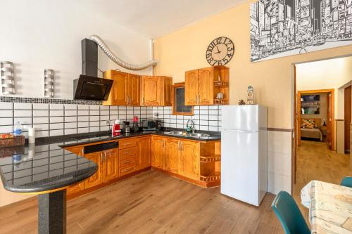 a kitchen with wooden cabinets and a white refrigerator at SALINETAS BLUE SURF HOUSE in Telde