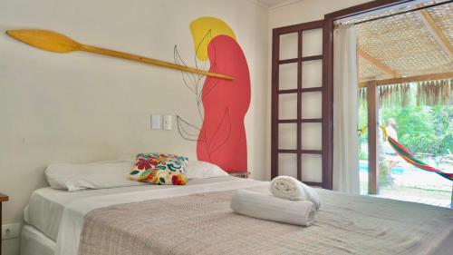 a bedroom with a bed with a large bird on the wall at Mangará Hostel e Hospedaria in Ilhabela