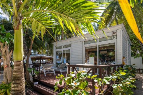 a small house with a table and a palm tree at Hotel Reina del Mar By Dorado in San Andrés