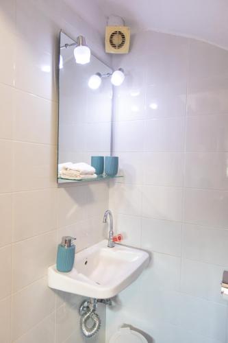 a white bathroom with a sink and a mirror at BS Village in Metamorfosi