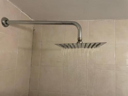 a shower with a shower head with water in it at Departamento 16 en el centro Tafi del Valle in Tafí del Valle