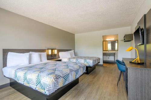 a hotel room with two beds and a desk at Motel 6-Spring Hill, FL - Weeki Wachee in Weeki Wachee