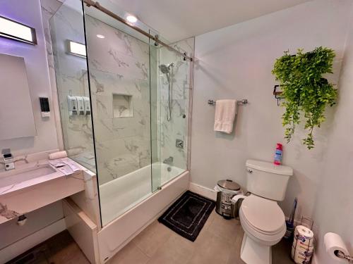 a bathroom with a shower and a toilet and a sink at The Modern Suite - 2BR Close to NYC in Paterson