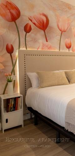 a bedroom with a bed with red flowers on the wall at Exclusive Apartment Center Gijón in Gijón