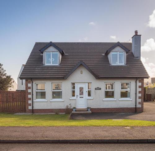 a white house with a black roof at Serenity House, Whitehall Ballycastle in Ballycastle