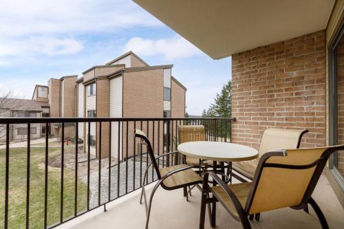 a balcony with a table and chairs and a building at Valleyview Swing & Stay in Traverse City