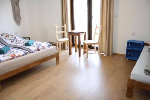 a bedroom with two beds and a table and chairs at WidziMiSie in Wetlina