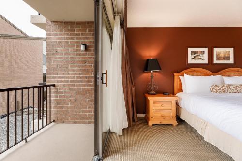 a bedroom with a bed and a brick wall at Valleyview Swing & Stay in Traverse City