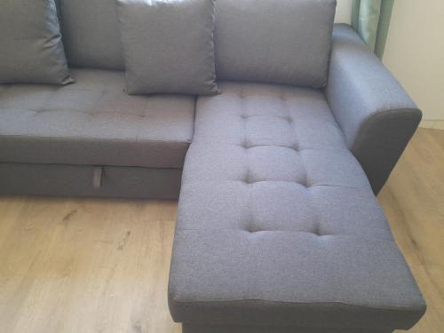 a grey couch sitting on top of a wooden floor at La Goyave de Cholet in Cholet