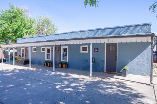 a blue building with a large garage at Zuni St Motor Inn- Bike, Dine, Explore Denver in Denver