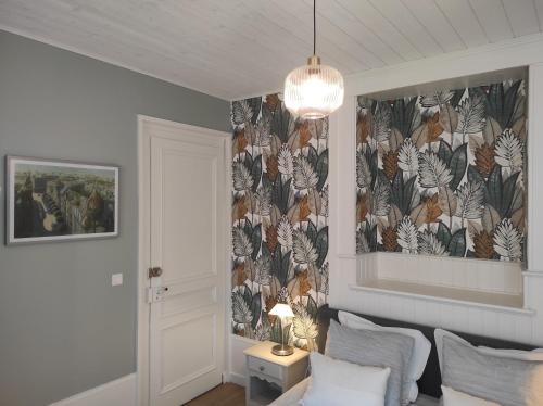 a living room with a wall with a floral wallpaper at Résidence de Vaux in Nans-sous-Sainte-Anne