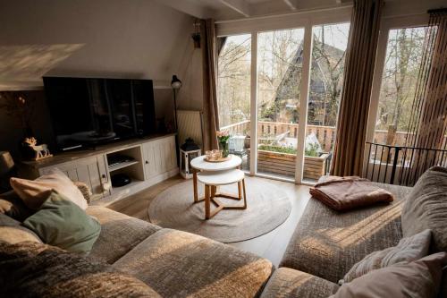 una sala de estar con un sofá y una mesa en Het Hertenbos Chalet 136 - Bos- Groene Oase- Rustmoment- Zwembad, en Durbuy