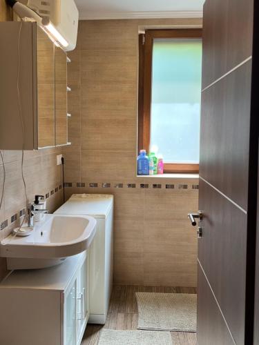 a bathroom with a white sink and a window at Tágas hely a parton in Balatonszárszó
