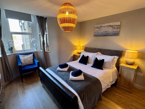 a bedroom with a large bed and a chandelier at Purbeck Hill View in Swanage