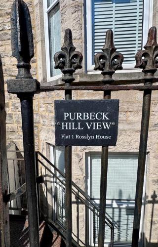 a sign on a fence in front of a building at Purbeck Hill View in Swanage