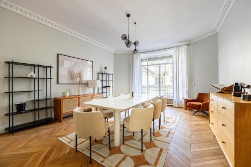une salle à manger avec une table et des chaises blanches dans l'établissement Luxurious 4 Bedroom Apartment, La Muette, à Paris