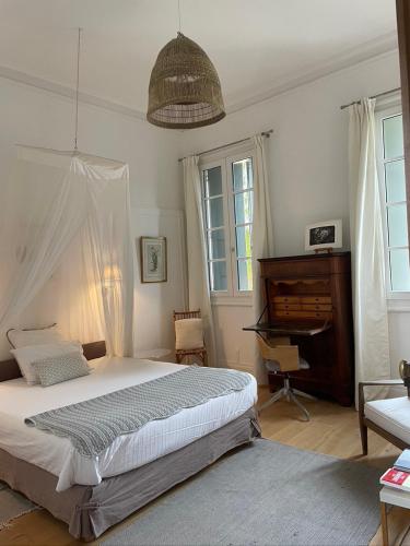 une chambre avec un grand lit et un piano dans l'établissement maison 3 chambres centre ville, jardin et bassin privatifs, à Montpellier