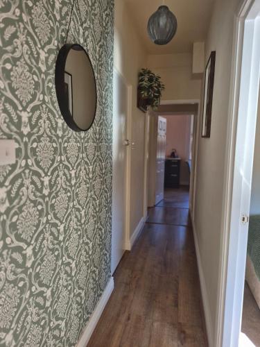 a hallway with a wall with a mirror and a hallway at City Centre Sanctuary with parking space in Worcester