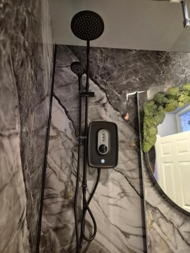 a bathroom with a shower with a phone on the wall at City Centre Sanctuary with parking space in Worcester