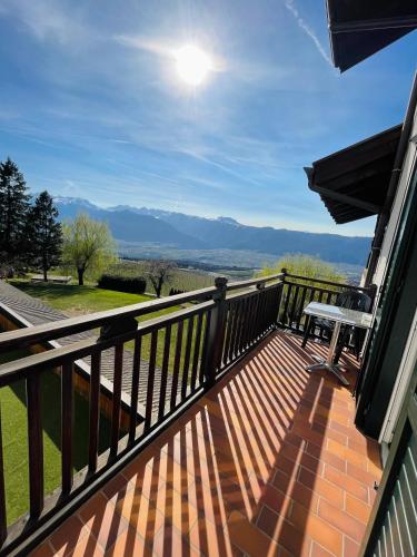 a balcony with a table and a view of the mountains at Enrosadira in Predaia