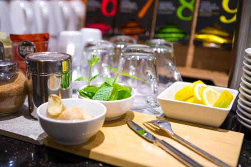 a wooden cutting board with bowls of food on a counter at Garner Hotel Essen - Handelshof by IHG in Essen
