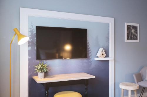 a room with a table and a tv on a wall at Garner Hotel Essen - Messe by IHG in Essen