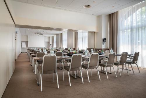 a conference room with tables and chairs in a building at Garner Hotel Essen - Handelshof by IHG in Essen